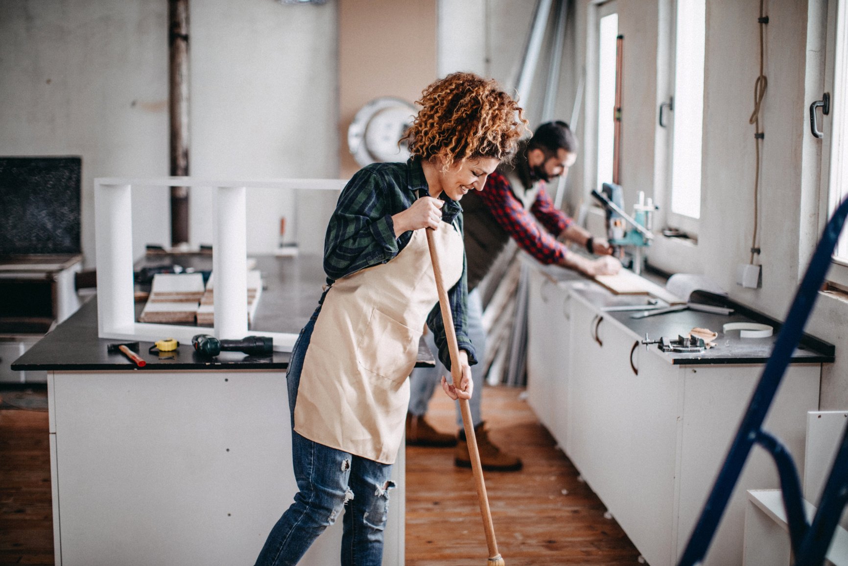 Young  couple cleaning a construction workshop